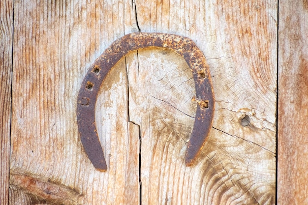 Foto altes verrostetes hufeisen auf einer alten holztür