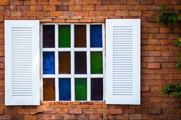 Altes weißes hölzernes Fenster mit Buntglas