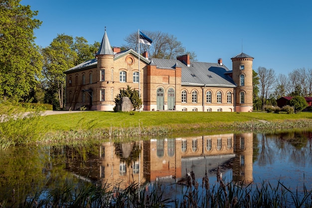 Foto altes ziegelstein-herrschaftshaus in lasila estland landschaft des anwesens mit spiegelung im teich