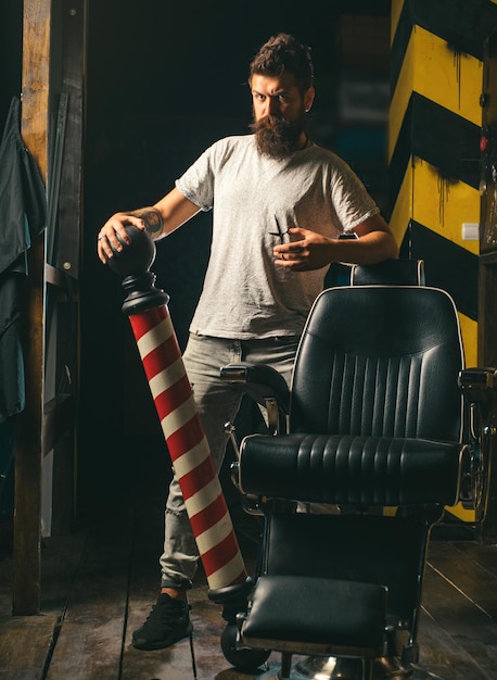 Foto altmodischer vintage-barbershop-pfeil, professioneller friseur in einem barbershop-innenraum, rasierer.