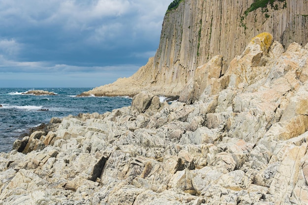 Alto acantilado costero formado por columnas de piedra Cabo Stolbchaty en la isla de Kunashir