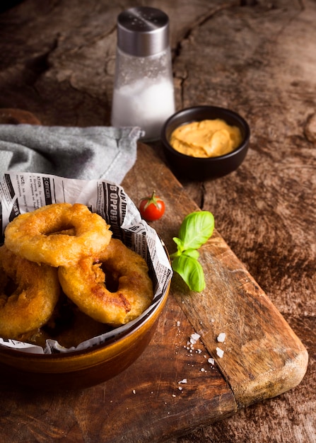 Alto ângulo de batatas fritas com mostarda e sal