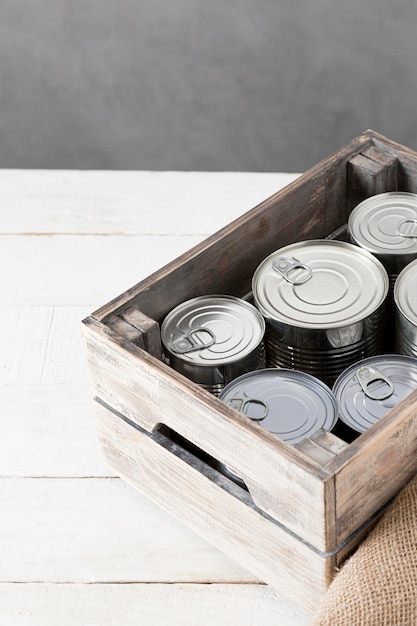 Alto ângulo de latas de alumínio em caixa de madeira com espaço para cópia