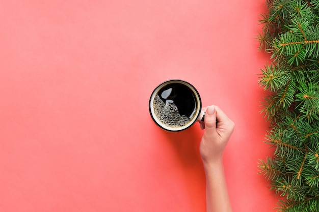 Alto ângulo de mãos de mulher segurando uma caneca de café em estilo minimalista de fundo rosa. vista plana leiga, isolada