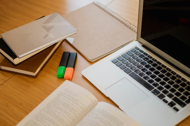 Alto ângulo de mesa com livros e laptop