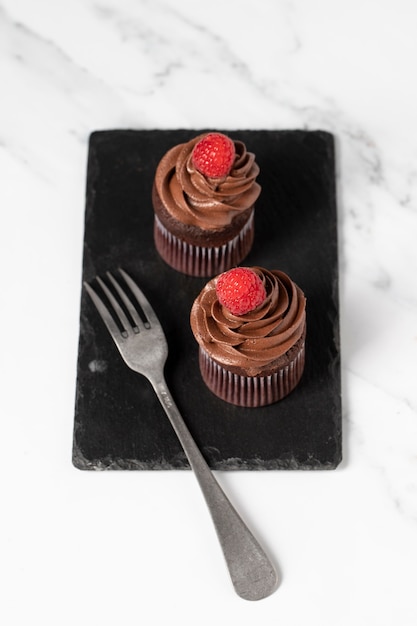 Foto alto ángulo de deliciosos cupcakes de chocolate con frambuesa