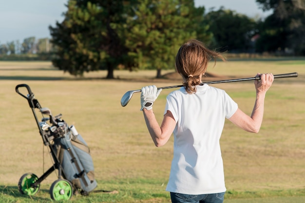 Alto ângulo feminino jogando golfe