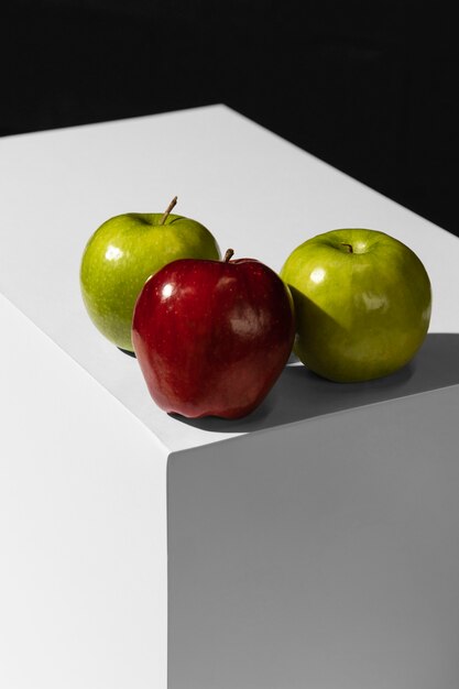 Foto alto ángulo de manzanas verdes y rojas en el podio