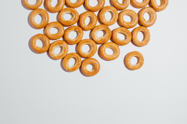 Alto ángulo de muchos bagels marrones apetitosos como una especie de panadería fresca y comida rápida sobre fondo blanco en estudio