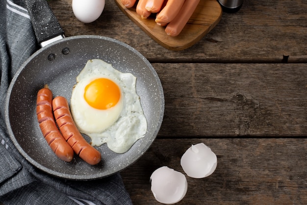 Alto ángulo de pan con huevo y salchichas para el desayuno.