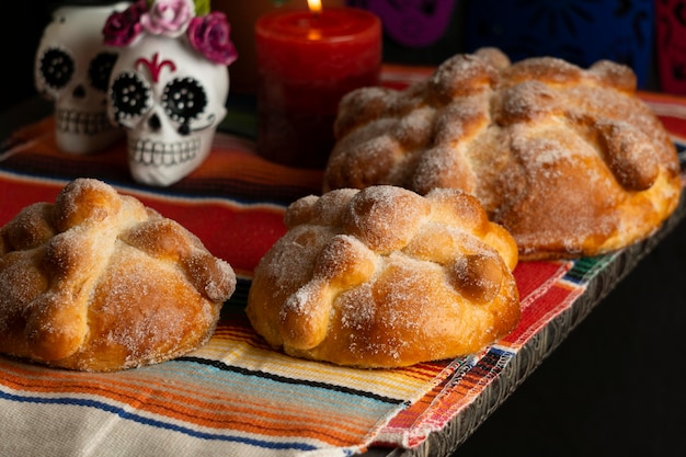 Foto alto ángulo de pan de muerto con vela y calavera