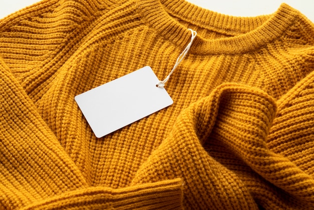 Alto ángulo de suéter con etiqueta en blanco