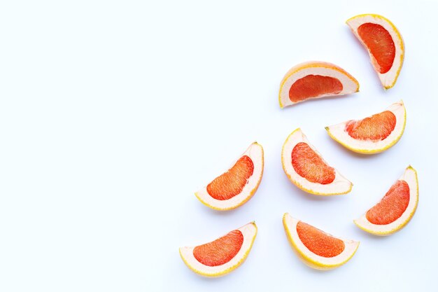 Alto contenido de vitamina C. Jugosas rodajas de pomelo en la pared blanca.