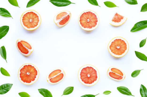 Alto contenido de vitamina C. Marco hecho de jugosas rodajas de pomelo sobre fondo blanco.