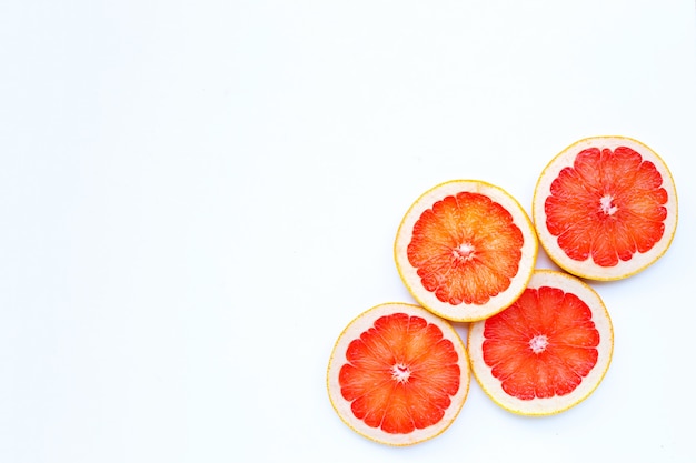 Alto contenido de vitamina C. Rodajas de pomelo jugoso en blanco.