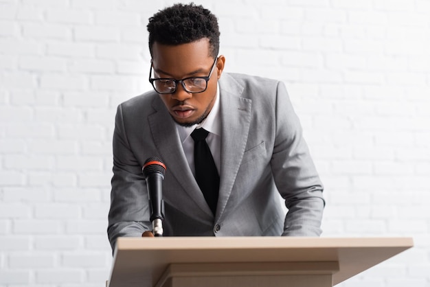 Alto-falante afro-americano nervoso em conferência de negócios no escritório