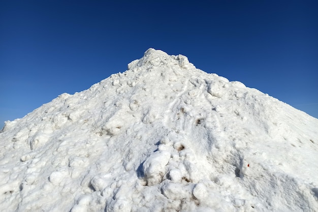 Alto montón de nieve blanca en un día soleado de invierno.