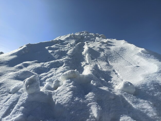 Alto montón de nieve blanca en un día soleado de invierno.