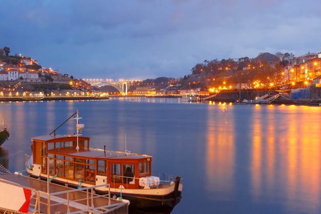 Altstadt von Porto mit Spiegelreflexionen im Fluss Douro während der blauen Abendstunde, Portugal, Portugal.