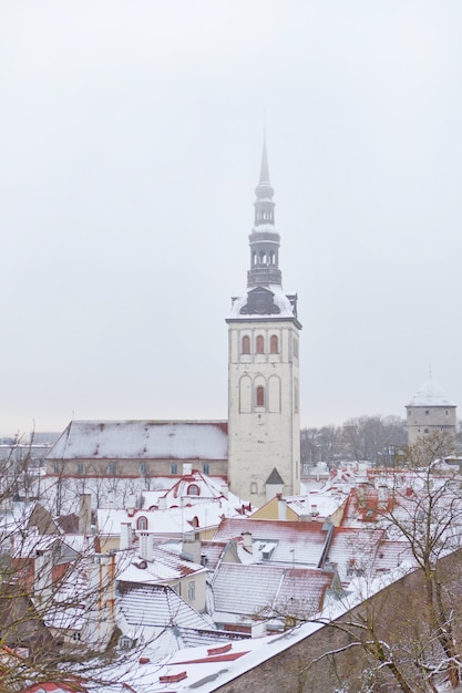 Altstadt von Tallinn, Estland. Vertikales Foto der St.-Nikolaus-Kirche, Niguliste-Fassade. Schnee und Dächer der Altstadt im Winter