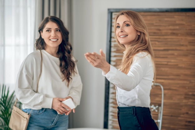 Alugando apartamento. Mulher jovem conversando com um corretor de imóveis sobre o aluguel de um apartamento