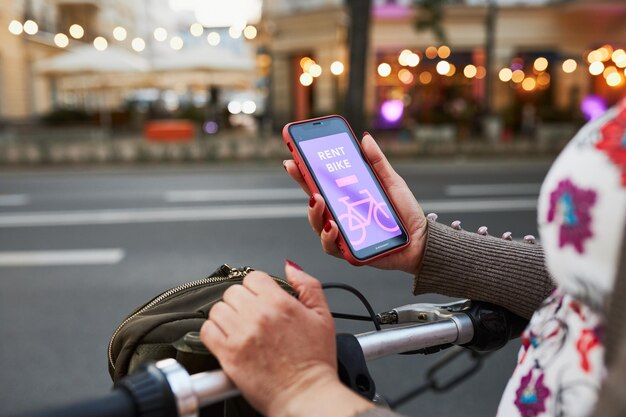 Foto alugar bicicleta usando aplicativo de aluguel em telefone móvel usando aplicativo móvel de serviço de compartilhamento de bicicleta da cidade