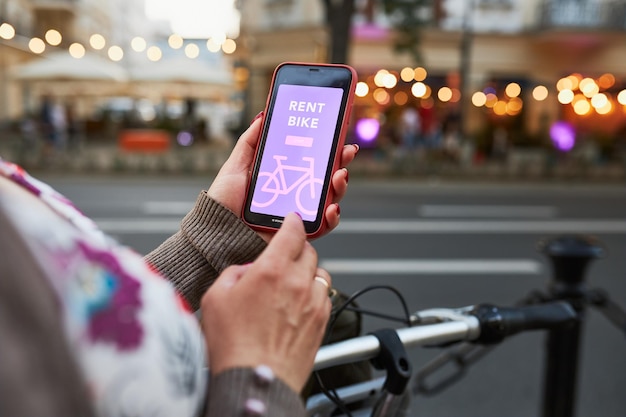 Foto alugar bicicleta usando aplicativo de aluguel em telefone móvel usando e-scooter compartilhamento de serviço de cidade transporte ecológico