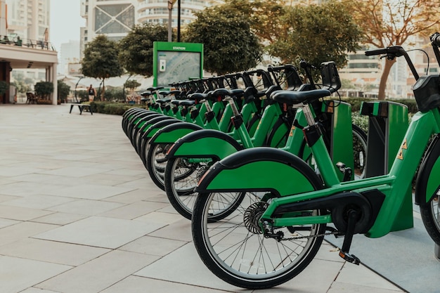 Aluguel público de bicicletas ecológicas verdes em uma fileira localizada do lado de fora em uma área de parque