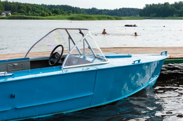 Foto aluminiumblaues fischerboot mit motor in der nähe des seeufers angeln aktive erholung