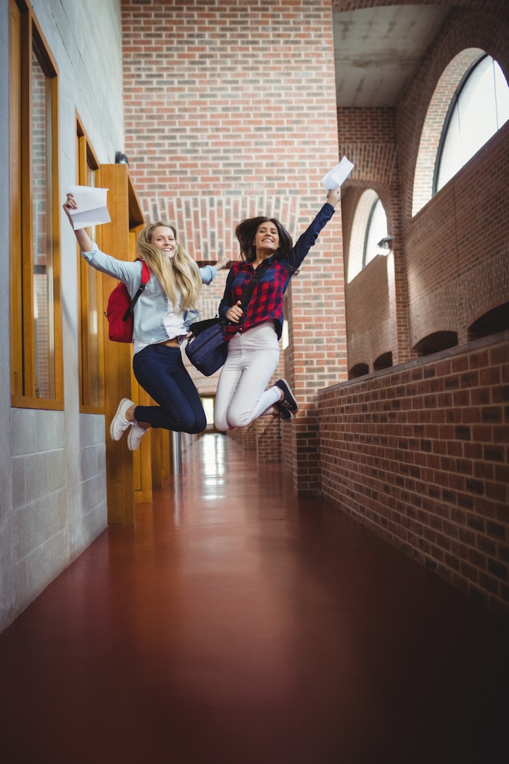 Foto alumnas felices recibiendo resultados en la universidad.