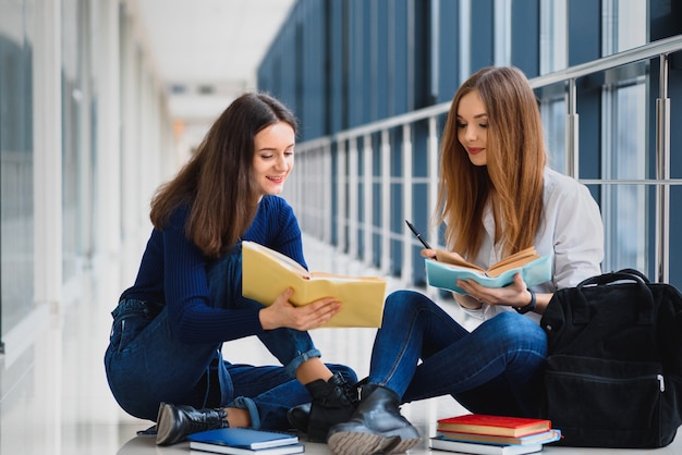 Alumnas sentadas en el suelo y leyendo notas antes del examen