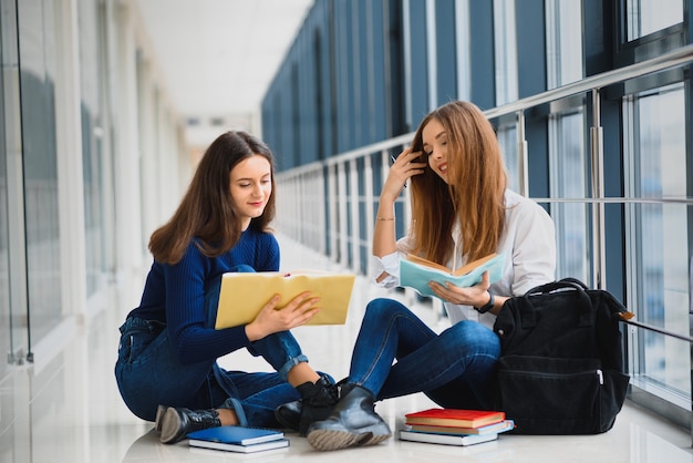 Alumnas sentadas en el suelo y leyendo notas antes del examen