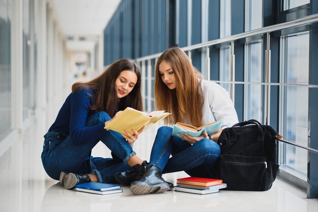 Alumnas sentadas en el suelo y leyendo notas antes del examen