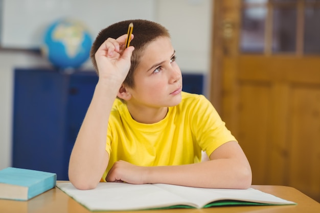 Alumno concentrado trabajando en su escritorio en un aula