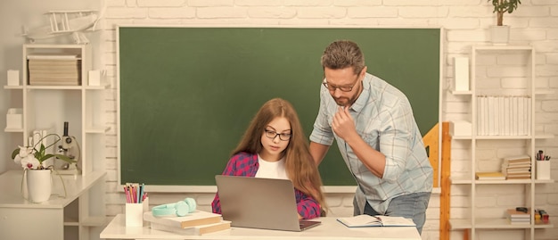 Alumno curioso y tutor con laptop padre y adolescente estudian profesor privado e hijo