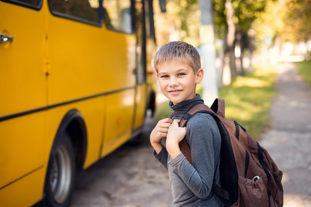 Alumno de la escuela que va a un autobús escolar después de las lecciones por la tarde