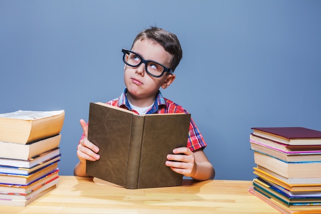 Alumno de gafas obteniendo conocimientos de un libro de texto