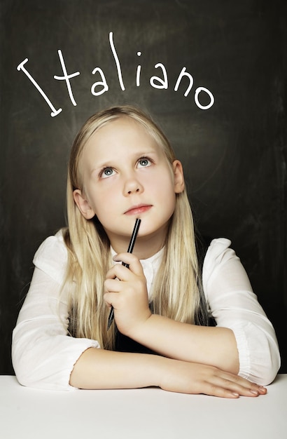 Alumno niña aprendiendo italiano femenino estudiante de primaria en el aula de la escuela fondo de pizarra