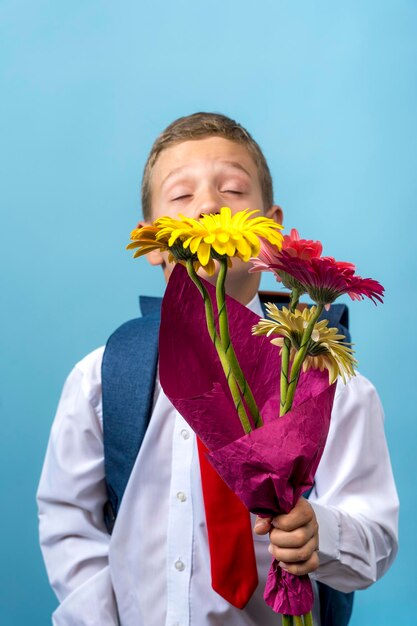 Alumno de primer grado con una mochila tiene un ramo de flores.