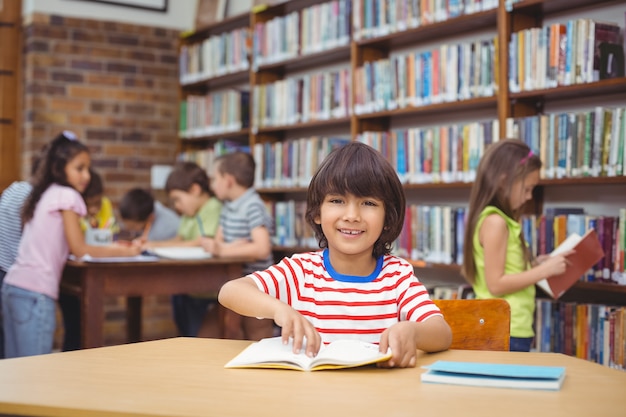 Alumno sonriendo a la cámara en la biblioteca