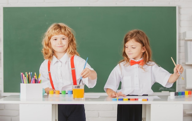 Alumnos divertidos dibuja en el aula en la escuela pizarra fondo escuela amigos niños niño y niña pai