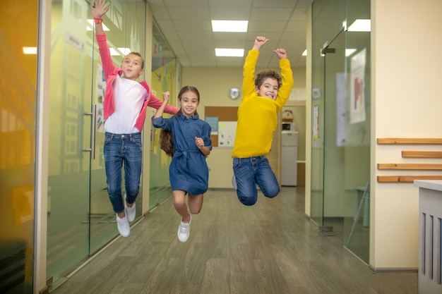 Alumnos de la escuela primaria sonrientes saltando