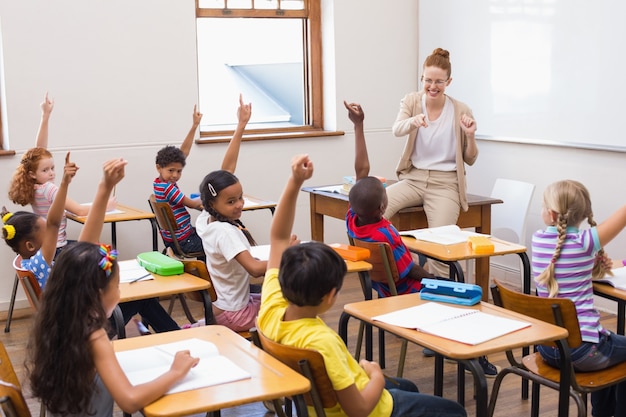 Alumnos levantando la mano en el aula