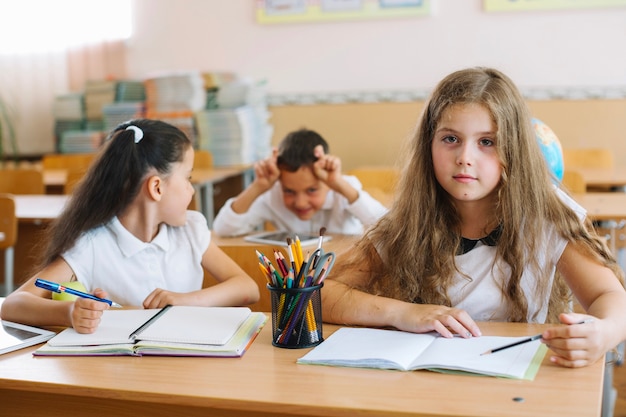 Alumnos sentados en los escritorios en el aula