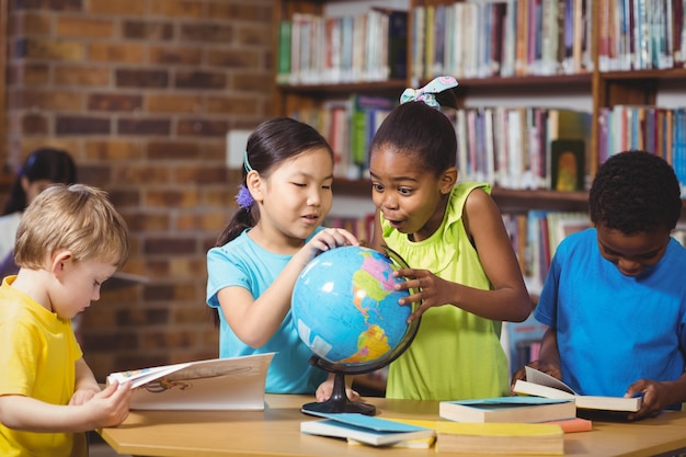 Alumnos sorprendidos estudiando el mundo en la biblioteca