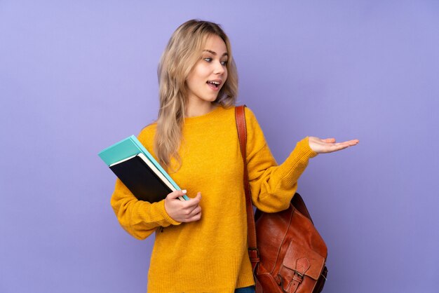 Aluna adolescente em roxo segurando copyspace com as duas mãos