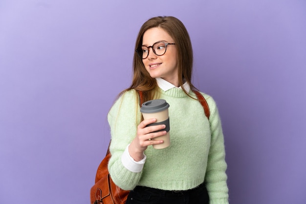 Aluna adolescente em um fundo roxo isolado, olhando para o lado e sorrindo