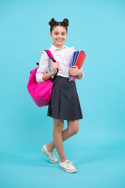 Aluna adolescente estudante segura livro no fundo azul isolado do estúdio Conceito de escola e educação De volta à escola Emoções positivas e sorridentes de adolescente feliz de adolescente