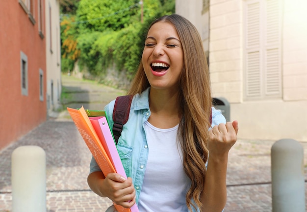 Aluna animada segurando cadernos