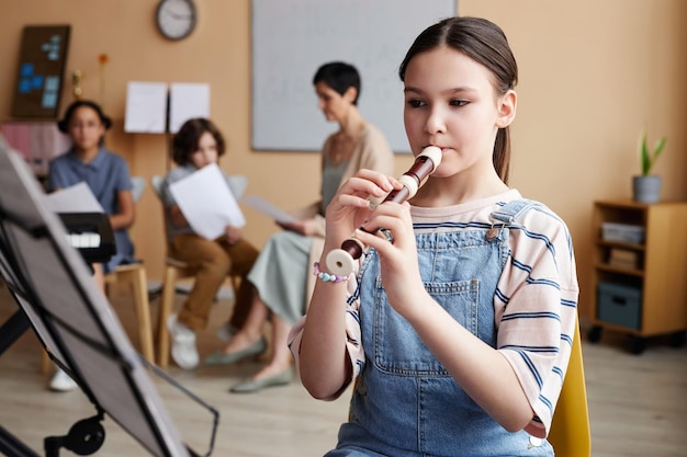 Aluna aprendendo a tocar flauta na aula